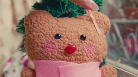 A Hand Attaching a Ribbon to a Customizable Bear at Build-A-Bear Workshop - Stock Footage 296279955