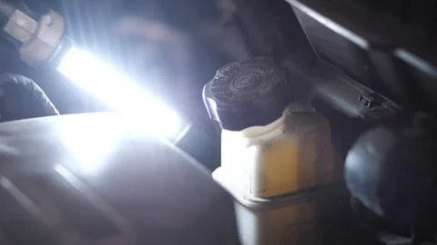 Hand of auto mechanic checking coolant level Stock Footage 123503293