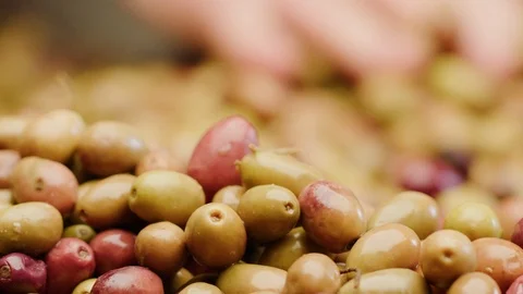 Hand in the background that passes between a pile of olives 4k Stock Footage 86807090
