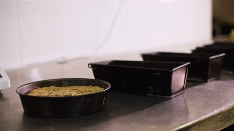 Hand the Baker sprinkles flour on the bread in the baking molds Stock Footage 106460043