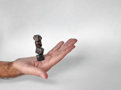Hand balancing stacked dice: precision and skill in tabletop gaming Foto stock