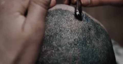 Hand of barber keeping straight razor and cutting trendy stripes on head Stock Footage 150271013