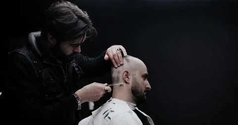 Hand of barber keeping straight razor and cutting trendy stripes on head Stock Footage 150273580