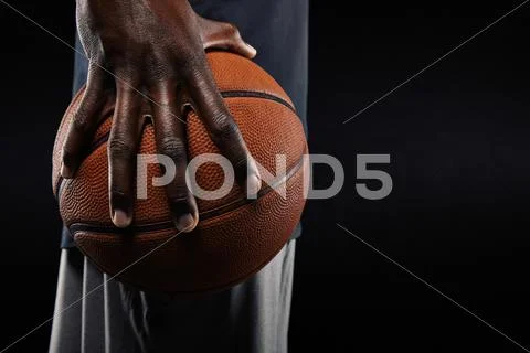 Hand of basketball player holding a ball Stock Photos