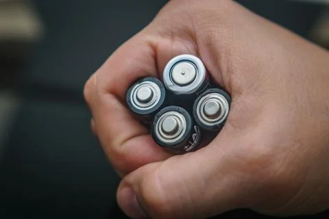 Hand with batteries Stock Photos