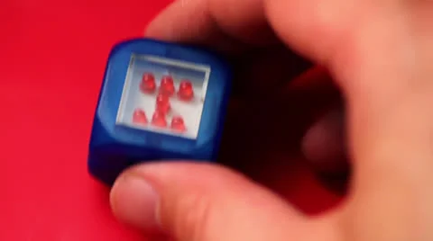 Hand beats by small toy cube with LED light flashes Stock Footage 22734645