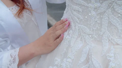 Hand of Beautiful Asian Bride Touching Her Wedding Dress Details Outside Stock Footage 333357642