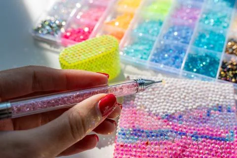Hand bedazzling a decorative object with sparkling rhinestones Foto stock
