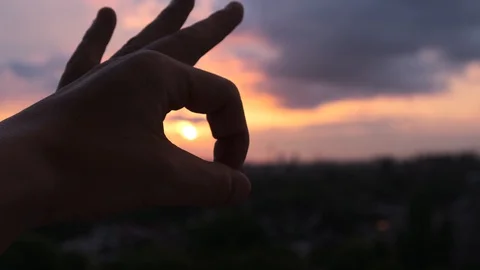 Hand being played with the sun at sunset Stock Footage 108661194
