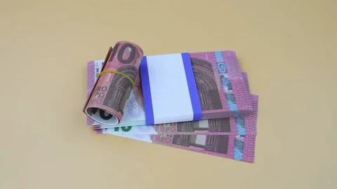 Hand in a black glove picks up a bundle of 10 euro banknotes lying on the table Vídeo Stock 142434525