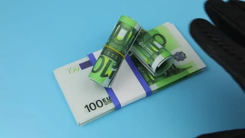 A hand in a black glove steals a bundle of 100 euro banknotes lying on a table 스톡 동영상 141526399
