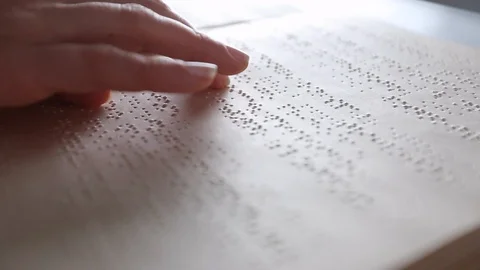 The hand of a blind man reads the text of a braille book. Video stock 120606841