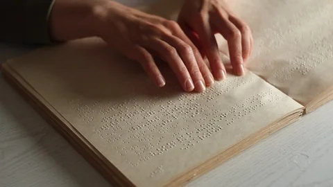 The hand of a blind man reads the text of a braille book. Stock Footage 120607797