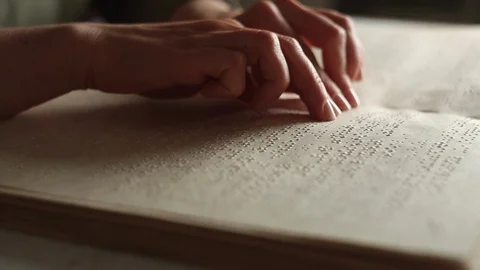The hand of a blind man reads the text of a braille book. Vídeo Stock 120607826