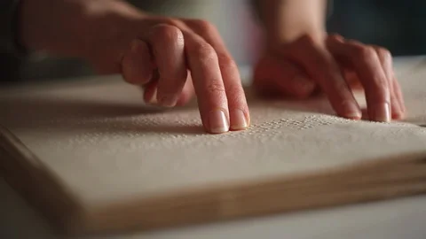 The hand of a blind man reads the text of a braille book. Video stock 120607829