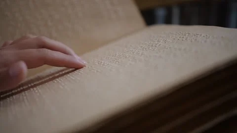 The hand of a blind man reads the text of a braille book. Stock Footage 196695386
