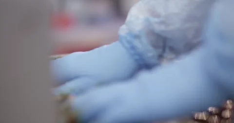 Hand in a blue glove layers marinated meat slices onto a large skewer in a food Vídeo Stock 339997967