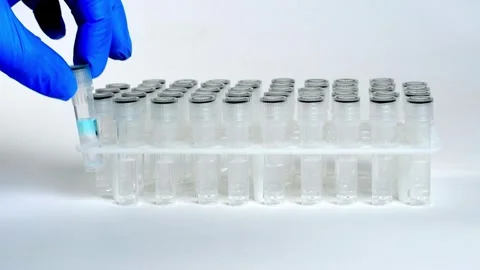 Hand in blue glove put vacuum tube to stand stand in laboratory, Stock Footage 255219880