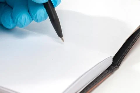 Hand in blue glove write on empty book Stock Photos