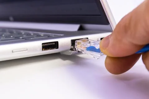 Hand blue lan cable ethernet port laptop notebook connection network plug Stock Photos