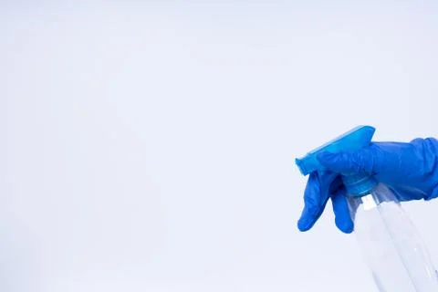 A hand with blue nitril gloves using a spray Stock Photos