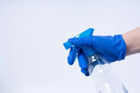 A hand with blue nitril gloves using a spray Stock Photos