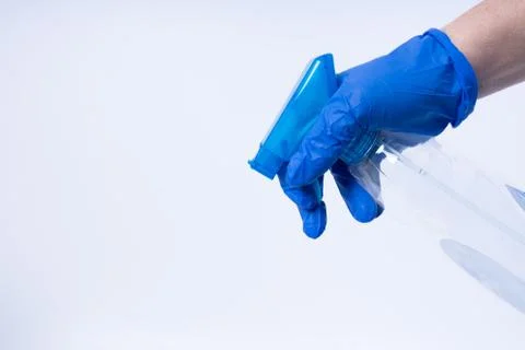 A hand with blue nitril gloves using a spray Stock Photos