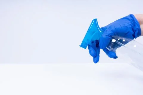 A hand with blue nitril gloves using a spray Stock Photos