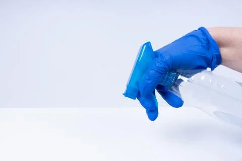 A hand with blue nitril gloves using a spray Stock Photos