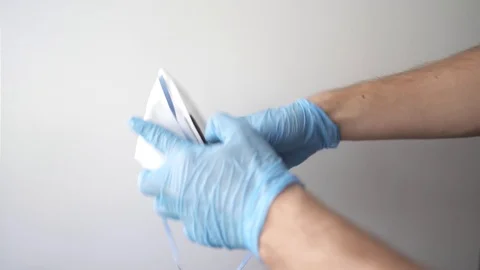 Hand in blue nitrile gloves holding mask sharing protective respirator. Stock Footage 127217669