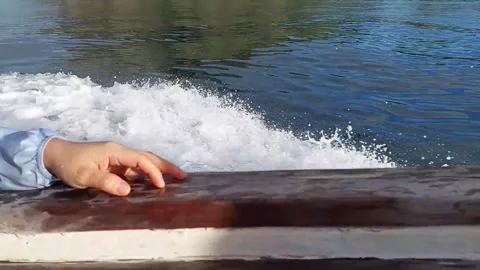 Hand on Boat Railing with Water Splashes at Labuan Bajo Stock Footage 279871792