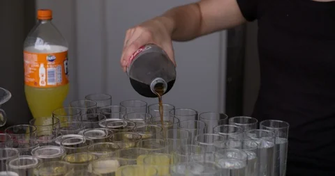 Hand with bottle pouring coca cola into glasses, medium shot Stock Footage 91864840