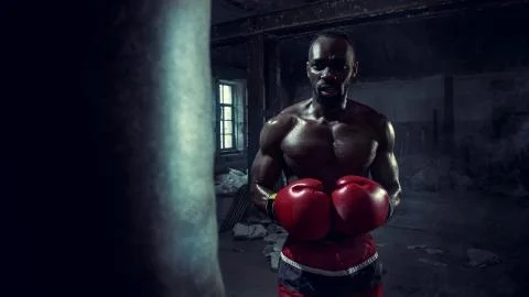 Hand of boxer over black background. Strength, attack and motion concept Stock Photos