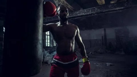 Hand of boxer over black background. Strength, attack and motion concept Stock Photos