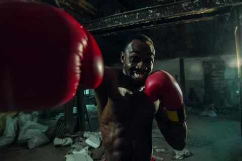 Hand of boxer over black background. Strength, attack and motion concept Stock Photos