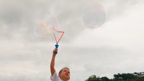 Hand of boy blowing soap bubble. Video stock 266779687