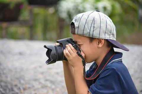 Hand boy holding the camera Taking pictures in park. Stock Photos