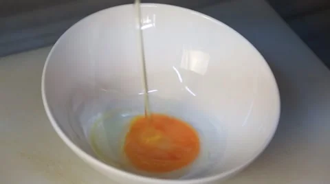 Hand Breaking an Egg For Cooking into a plate Stock Footage 54924660