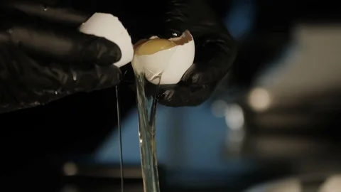 Hand breaking eggshell Stock Footage 125458417