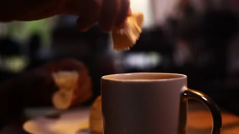 Hand breaking of a piece of Filipino bread called Pandesal and dipping it into Stock Footage 336033294