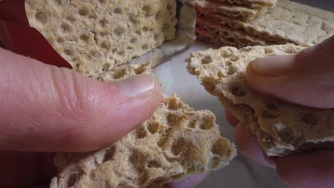 Hand breaking a piece of rye crispbread in half. Stock Footage 115261995