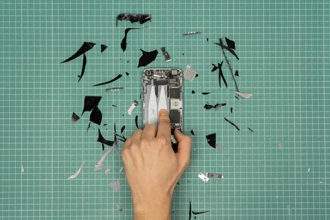 Hand breaking a smartphone. Stock Photos