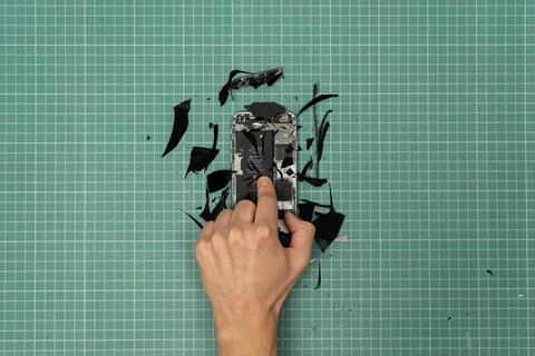 Hand breaking a smartphone. Stock Photos