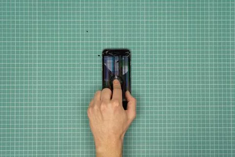 Hand breaking a smartphone. Stock Photos