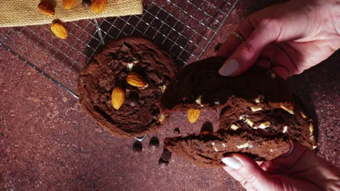 Hand Breaking Soft Chocolate Cookie With Almonds Showing Fresh Baked Center Stock Footage 331981774