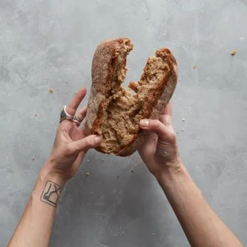 Hand breaks bread 스톡 사진