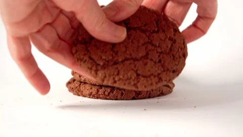 A hand breaks a cookie on a white background. Sweet food and snacks. Stock Footage 169599865