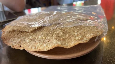 Hand breaks the flatbread Crispy flatbread hand paratha and roasting it on live Vídeo Stock 306276203