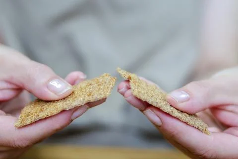 The hand breaks the loaf of bread into two parts. Preparing snacks in the form Foto stock
