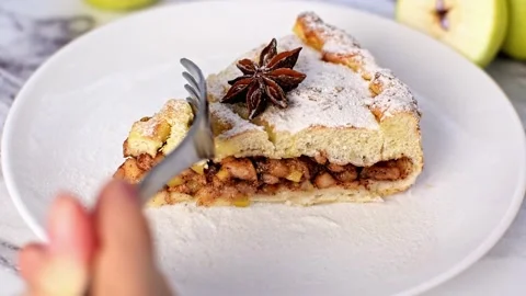 Hand breaks off piece of apple cinnamon cake with a fork close-up. Stock Footage 236476576